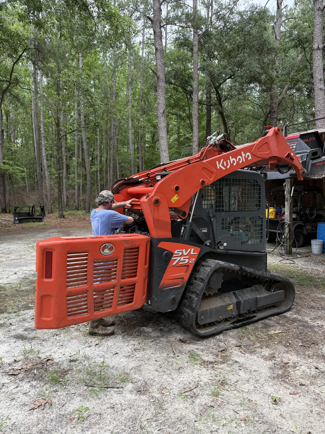 Kubota compact track loader on a cleared woods lane