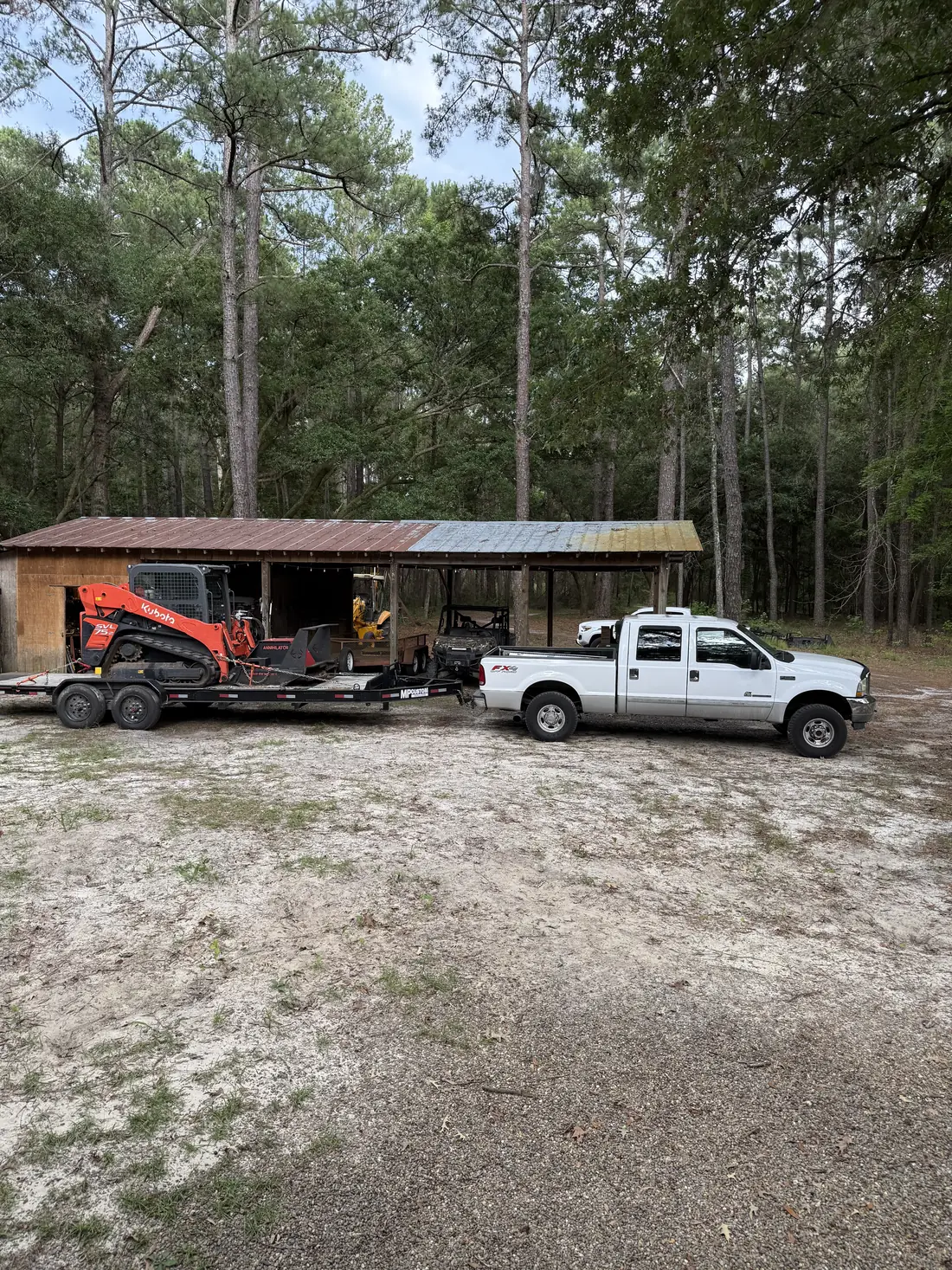 Tracked mulching machine staged on a trailer for a Lowcountry lot job